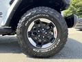 Close-up of a black alloy wheel with BFGoodrich all-terrain tires mounted on a 2021 Jeep Wrangler