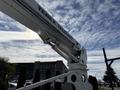 A Terex Telelect mounted on a 2008 Kenworth T370 with a large extending boom positioned upward against a cloudy sky