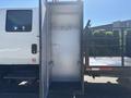 A white 2011 International 4300 truck with an open cargo area showing metal hooks and an empty interior space