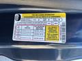 A yellow tire and loading information label affixed to a vehicle displaying seating capacity and recommended tire pressures