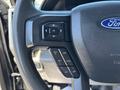 Steering wheel controls of a 2022 Ford F-350 SD featuring buttons for navigation and cruise control adjustments