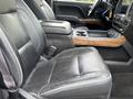 Interior view of a 2017 Chevrolet Silverado 1500 featuring black leather seats with white stitching and a wooden console in the center