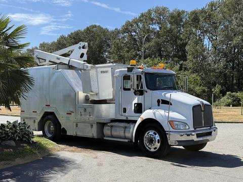 A 2009 Kenworth T270 truck with a white exterior and utility equipment on the back, featuring an elevated platform and yellow warning lights