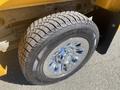 A close-up of a tire and wheel from a 2013 Chevrolet Silverado 1500 featuring chrome rims and a treaded tire designed for improved traction
