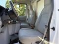 Interior of a 2021 Ford Econoline featuring two gray fabric seats and a steering wheel with a simple dashboard design