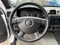 Steering wheel of a 2012 GMC Canyon with the GMC logo visible in the center and dashboard gauges in the background