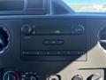 Dashboard control panel of a 2019 Ford E-450 featuring audio controls and a digital clock display