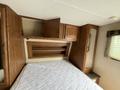 Interior view of a 2013 Outdoor Wind River featuring wooden cabinets a shelf and a space for a mattress