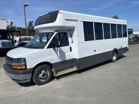 A white 2020 Chevrolet Express shuttle bus with large windows and a step at the entrance