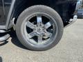 A close-up of a chrome wheel and tire from a 2003 Hummer H2 showing multiple spokes and a distinctive tread pattern