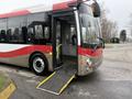 A red and silver 2016 Grande West Vicinity bus with an open door and a ramp for accessibility