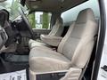 Interior view of a 2008 Ford F-450 SD showing two beige fabric front seats with a center console between them