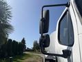 A side view mirror of a 2014 Freightliner M2 106 truck showcasing its black design and adjustment mechanism