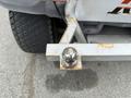A metal trailer hitch ball mounted on a bumper with some rust visible