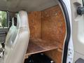 Interior view of a 2008 Ford F-450 SD showing a wooden partition with hooks and a shelf behind the driver's seat