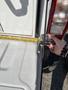 A hand holding a measuring tape against the corner of a 2018 Westland Travelaire trailer showing measurement of the vehicle's edge