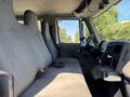 A 2011 International 4300 truck interior featuring two grey upholstered seats and a steering wheel visible from the driver's side