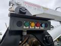 A control panel with five buttons labeled in different colors including red green and yellow mounted on a mechanical arm