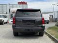A 2017 Chevrolet Tahoe seen from the rear with no visible license plate and a dark exterior color