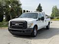 A white 2011 Ford F-350 SD pickup truck with a black grille and front bumper parked on a paved surface