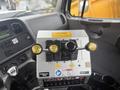 A control panel featuring several levers and buttons labeled for various functions including down left right and up positioned inside a 2016 Freightliner 108SD cab