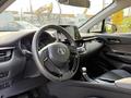 Interior view of a 2021 Toyota C-HR showcasing the steering wheel dashboard and gear shift