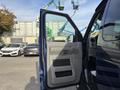 A 2013 Ford E-350 Super Duty with the driver's side door open showcasing the interior door panel and handle
