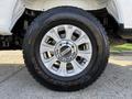 A close-up view of a 2021 Ford F-250 SD wheel featuring a chrome five-spoke rim and a Goodyear Wrangler tire with visible tread and branding