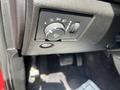 A close-up of the control panel in a 2015 Jeep Grand Cherokee showing the headlight switch and several adjustment knobs.