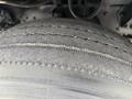 Close-up of a worn tire on a 2004 Ford F-750 showing visible tread wear and damage