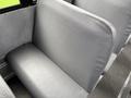 A gray upholstered seat in a vehicle interior with a smooth surface and slight texture