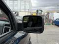 A 2018 RAM 1500 viewed from the driver's side with a focus on the side mirror and part of the interior cabin visible through the window