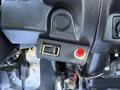 A control panel with a black switch and a red button labeled with warning signs inside a 2015 Hino 358 vehicle