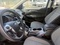 Interior of a 2014 Ford Escape featuring a steering wheel sleek dashboard and two-tone front seats with central console and gear shift
