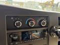 Dashboard controls of a 2020 Chevrolet Express including knobs for temperature and fan speed along with a digital display and music control buttons