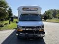 A 2020 Chevrolet Express prominently displays the words "SAFE BUS" on its electronic sign with a black grill guard and side mirrors visible in the foreground