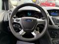 A close-up view of the steering wheel and dashboard of a 2017 Ford Transit Connect displaying dials and controls