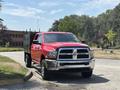 A red 2013 RAM 2500 truck with a black bed and shiny chrome grille parked at an angle on a paved surface