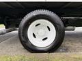 A close-up of a white tire mounted on a wheel of a 2022 Ford E-450 showing the tread pattern and wheel design