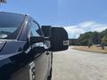 A black 2022 Ford F-350 SD with a prominent side mirror showing its robust design and chrome accents