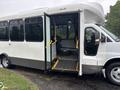 A white 2018 Chevrolet Express shuttle bus with an open door revealing interior seats and flooring