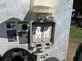 A weatherproof electrical outlet with two sockets mounted on a metal panel featuring warning labels about safety and compliance