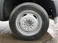 A close-up view of a silver alloy wheel and tire from a 2012 Ford F-450 SD showcasing the tread patterns and wheel design