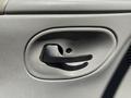 Close-up of a door handle on the interior of a 2006 Ford Econoline with a simple black lever design on a light gray panel