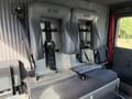 Two gray firefighter seats secured to a metal frame with straps visible on the backrest in an emergency vehicle interior