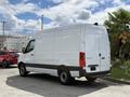 A 2022 Mercedes-Benz Sprinter van with a white exterior and black accents viewed from the rear angle