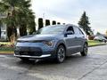 A blue 2023 Kia Niro EV parked on a paved surface showcasing its modern design and features