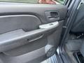 A close-up view of the interior door panel of a 2011 Chevrolet Avalanche featuring a handle and control buttons