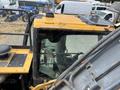 A 2018 John Deere 350 construction vehicle featuring a yellow and black exterior with a large cab and various controls visible inside the cabin