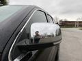 A 2019 Jeep Grand Cherokee with a polished side mirror reflecting a person and nearby trees